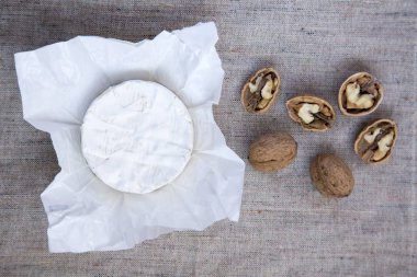 Yuvarlak peynir camembert veya kağıt ile ceviz brie. Metni kopyalayın. Düz yatıyordu. Üstten Görünüm. Yukarıdan. Eski çuval bezi doku.