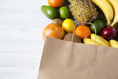 Beyaz ahşap zemin üzerinde farklı meyve kese kağıdı. Düz yatıyordu. Üstten Görünüm. Kopya alanı.