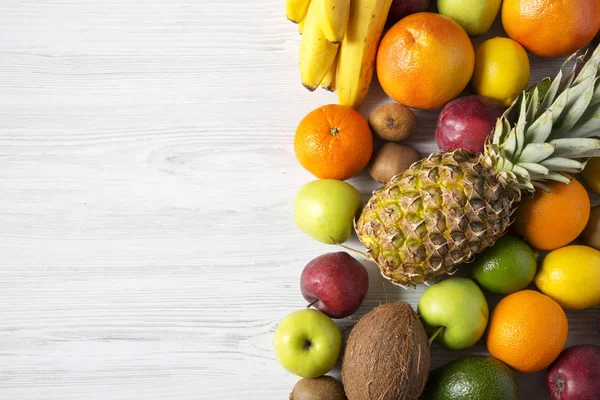 Beyaz ahşap zemin üzerinde farklı meyve. Düz yatıyordu. Üstten Görünüm. Kopya alanı.