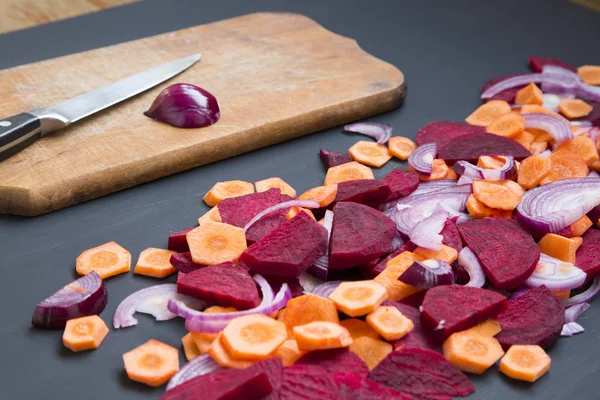 Verduras frescas picadas con cuchillo sobre fondo oscuro. Tabla de cortar. Vista lateral . — Foto de Stock