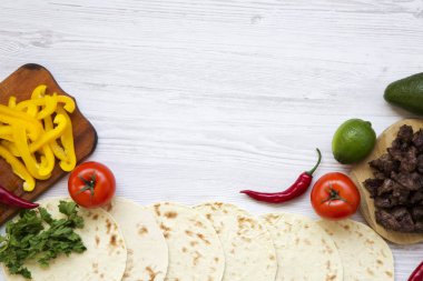 Ekmeği malzemelerle tacos beyaz tahta masada yemek pişirmek için. Üstten Görünüm. Yukarıdan. Düz yatıyordu. Kopya alanı.