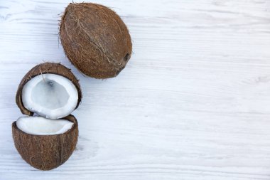 Hindistan cevizi yarısı beyaz tahta arka plan ile. Uzay kopyalayın. Üstten Görünüm. Yukarıdan.