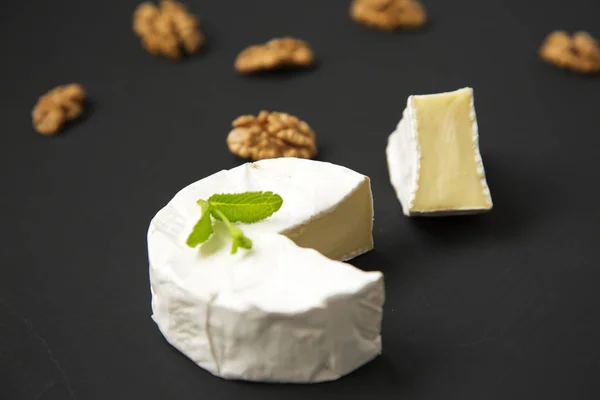 Sýr camembert nebo brie na tmavém pozadí. Produkce mléka. Boční pohled. Closeup. — Stock fotografie