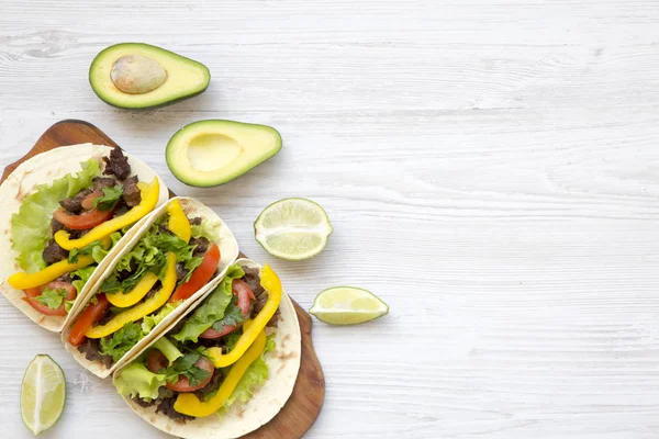 Tacos with pork, fresh vegetables, avocado, lime. White wooden background. Top view, flat, overhead. Copy space. — Stock Photo, Image