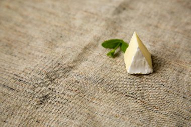 Brie veya camembert peyniri rustik arka plan üzerinde bir parça. Süt üretimi. Yan görünümü. Kopya alanı. 