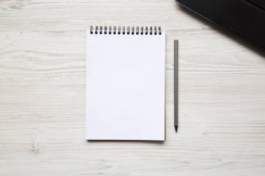 Boşluk dizüstü bilgisayar ve notebook Beyaz ahşap zemin üzerinde çalışıyorum. Üstten Görünüm. Düz yatıyordu.