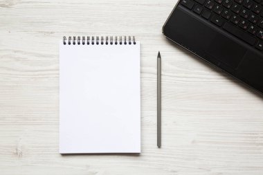 Boşluk dizüstü bilgisayar ve notebook Beyaz ahşap zemin üzerinde çalışıyorum. Üstten Görünüm. Düz yatıyordu.