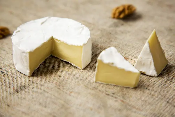 Camembert de queijo e fatias com nozes. Vista lateral . — Fotografia de Stock