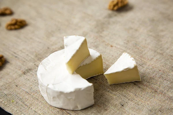 Camembert sajt és dió szeleteket. Oldalnézet. — Stock Fotó