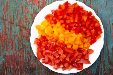 Renkli ahşap masa üzerinde plaka üzerinde kıyılmış taze sebze kümesi. Yukarıdan. Üstten Görünüm