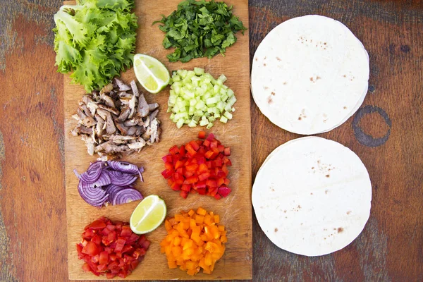 Ingredientes Tacos. Conjunto de verduras frescas en rodajas con carne de res, lima y tortillas sobre tabla de madera. Vista superior. Acostado. Desde arriba . —  Fotos de Stock