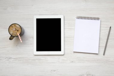 Sütlü buz, tablet ve defter ile kadınsı çalışma alanı. Üstten Görünüm. Yukarıdan.