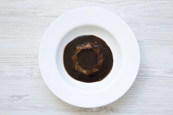 Panacotta dessert with chocolate in white plate on white wooden background. Flat lay. Top view. From above. — Stock Photo, Image