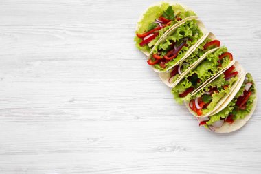 Beyaz ahşap zemin üzerinde altı taze vejetaryen yemek. Yukarıdan. Üstten Görünüm. Kopya alanı