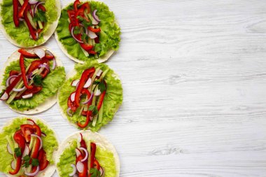 Üstten Görünüm Mısır ekmeği redish, salatalık, soğan, maydanoz, biber ve beyaz tahta masada, yukarıdaki marul ile. Kopya alanı.