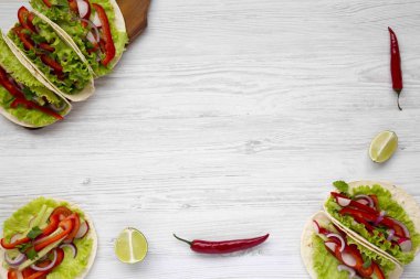 Mısır ekmeği redish, salatalık, soğan, maydanoz, biber ve marul üzerine beyaz ahşap masa ile yukarıda. Uzay kopyalayın. Üstten Görünüm.