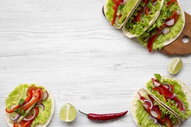 Üstten Görünüm Mısır ekmeği redish, salatalık, soğan, maydanoz, biber ve beyaz tahta masada, yukarıdaki marul ile. Kopya alanı.