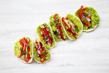 Beyaz ahşap zemin üzerinde taze vejetaryen yemek. Yukarıdan. Üstten Görünüm