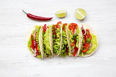 Mısır ekmeği redish, salatalık, soğan, maydanoz, biber ve marul üzerine beyaz tahta arka plan ile yukarıda. Üstten Görünüm.