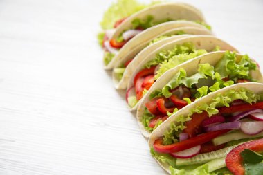 Marul, redish, salatalık, soğan, maydanoz ve beyaz tahta masada biber Mısır ekmeği. Uzay kopyalayın. Yan görünümü. Portre.