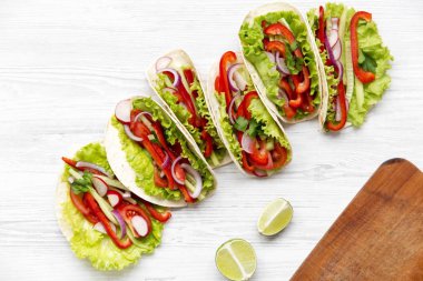 Beyaz ahşap zemin üzerinde taze vejetaryen yemek. Yukarıdan. Üstten Görünüm