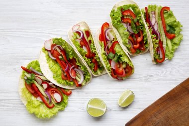 Beyaz ahşap zemin üzerinde taze vejetaryen yemek. Yukarıdan. Üstten Görünüm