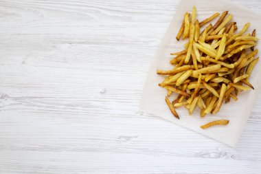 Patates kızartması üzerinde beyaz ahşap tahta, üstten görünüm, yakın çekim. Düz yatıyordu. Kopya alanı.