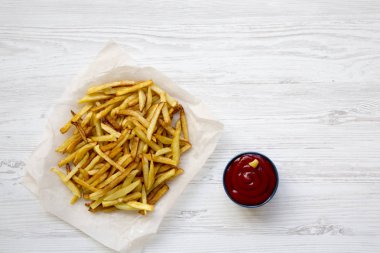 Patates kızartması Beyaz ahşap arka plan, üstten görünüm, ketçap ile kapatın. Düz yatıyordu. Kopya alanı.