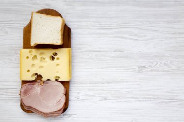 Sandviç yapmak için malzemeler kümesi: tost ekmek, peynir ve domuz pastırması Beyaz ahşap zemin üzerinde. Uzay kopyalayın. Üstten Görünüm.