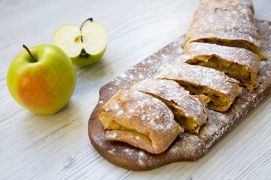 Ahşap masa, yan görünüm üzerinde pudra şekeri ile Apple strudel. Portre.