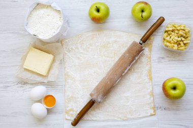 Strudel veya Beyaz ahşap zemin, üstten görünüm üzerine elmalı turta yemek pişirmek için malzemeler. Düz yatıyordu.