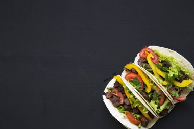 Sığır eti ve sebze siyah bir arka plan, üstten görünüm ile Mısır ekmeği. Meksikalı mutfak. Uzay kopyalayın. Düz yatıyordu.