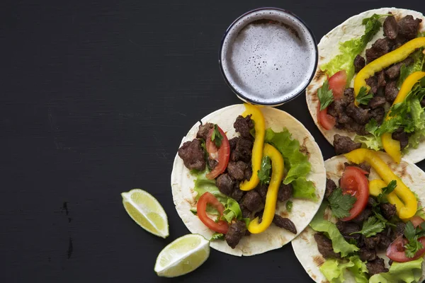 Mısır ekmeği sığır eti ve sebze, bira ve kireç siyah bir arka plan ile görünüm üst. Meksikalı mutfak. Uzay kopyalayın. Düz yatıyordu. — Stok fotoğraf