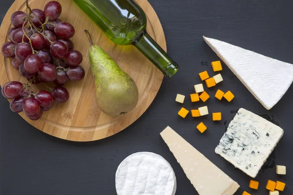 Verkostung von Käse mit Früchten und Wein auf dunklem Hintergrund. Essen für Romantiker. flach lag. von oben, Ansicht von oben. — Stockfoto