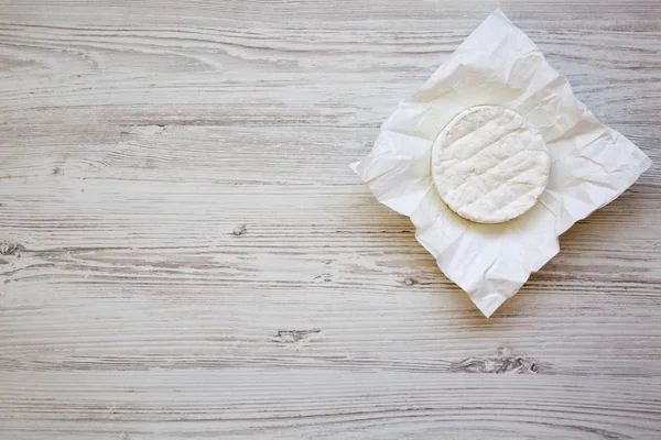 Camembert peyniri Beyaz ahşap zemin üzerinde kağıt üzerinde. Yiyecek şarap için. Yukarıdan. Üstten Görünüm, kopya alanı — Stok fotoğraf