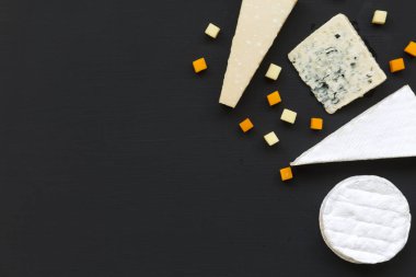 Peynir koyu arka plan üzerinde farklı türleri kümesi. Romantik yemek. Düz yatıyordu. Yukarıdan görünüm üst. Kopya alanı.