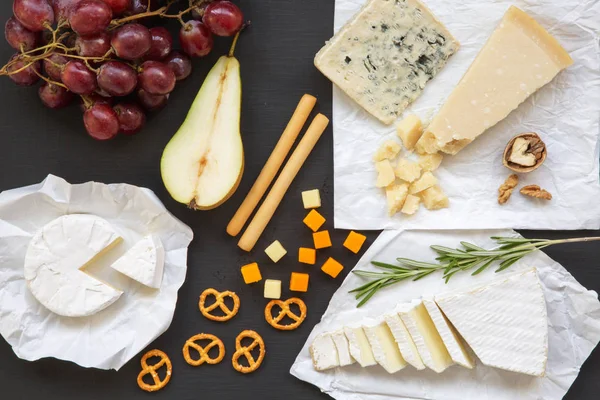 Köstlicher Käse Mit Früchten Brezeln Walnüssen Und Stockbrot Auf Dunklem — Stockfoto