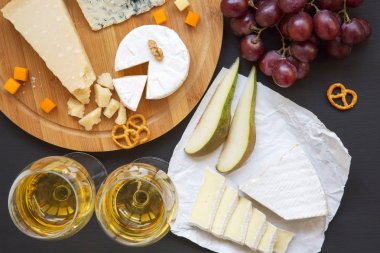 Şarap, meyve, çerez ve ceviz koyu arka plan üzerinde birlikte yukarıdan peynir. Üstten Görünüm. Düz yatıyordu.