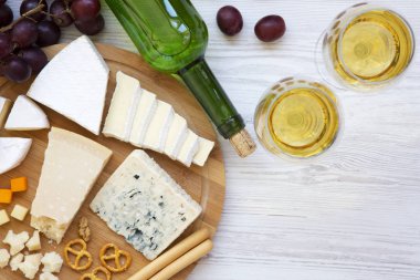 Şarap, üzüm, ceviz ve simit ahşap arka plan, üstten görünüm üzerinde lezzetli peynir tatma. Romantik yemek. Yukarıdan. Düz yatıyordu. 