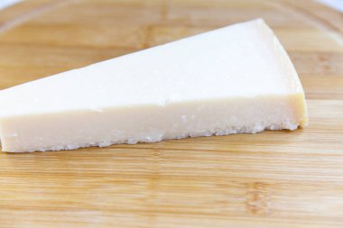 Parmesan peyniri ahşap tahta üzerinde parçası. Portre. Yan görünüm.