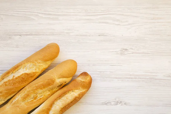 新鲜法国面包白色木质背景 顶部视图 复制空间 — 图库照片