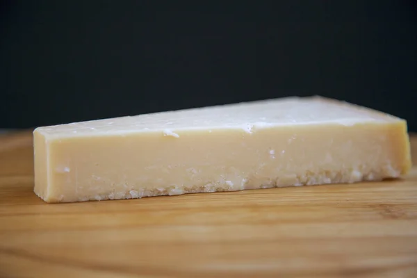 一块在木板上的干酪干酪 侧面视图 — 图库照片