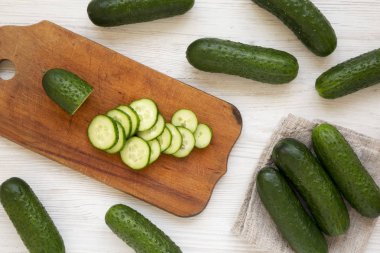 Kırsal bir tahta üzerinde küçük bebek salatalıkları doğradım. 