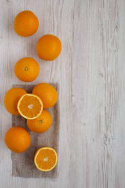 Beyaz ahşap bir masada taze taze organik portakallar, üst manzara. Birlikte