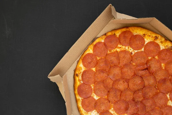 검은 배경 위의 상자 안에 있는 맛있는 페퍼로니 피자, 맨 위 뷰. — 스톡 사진