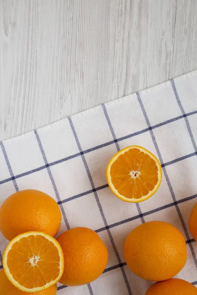 Fresh ripe organic oranges on a white wooden surface, top view.