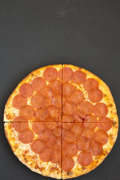 Deliziosa pizza Pepperoni su sfondo nero, vista dall'alto. Overh — Foto Stock
