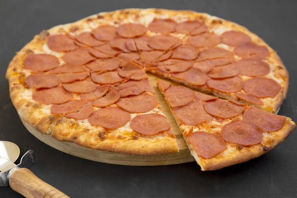 Sabrosa pizza de pepperoni sobre fondo negro, vista lateral. Primer plano — Foto de Stock