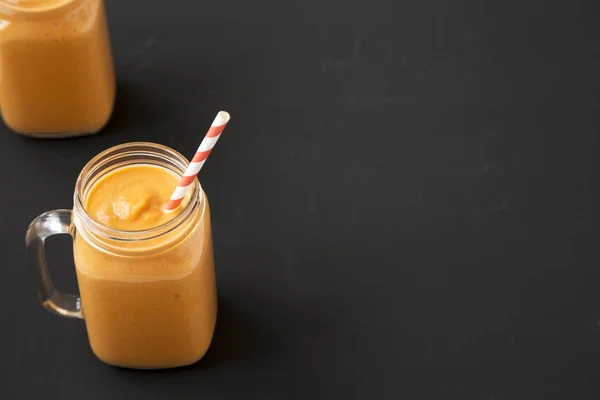 Pumpkin smoothie buatan sendiri dalam toples kaca di atas permukaan hitam, rendah — Stok Foto