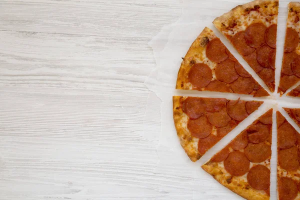 흰 나무 표면에 양피지에 있는 맛있는 페퍼로니 피자는 — 스톡 사진